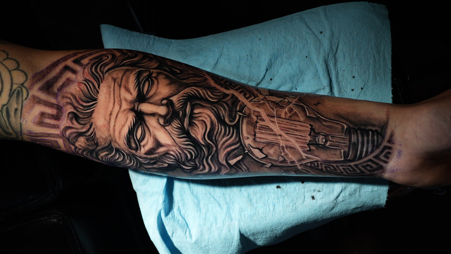 Zeus y bombilla — tatuaje black and gray de Kozo