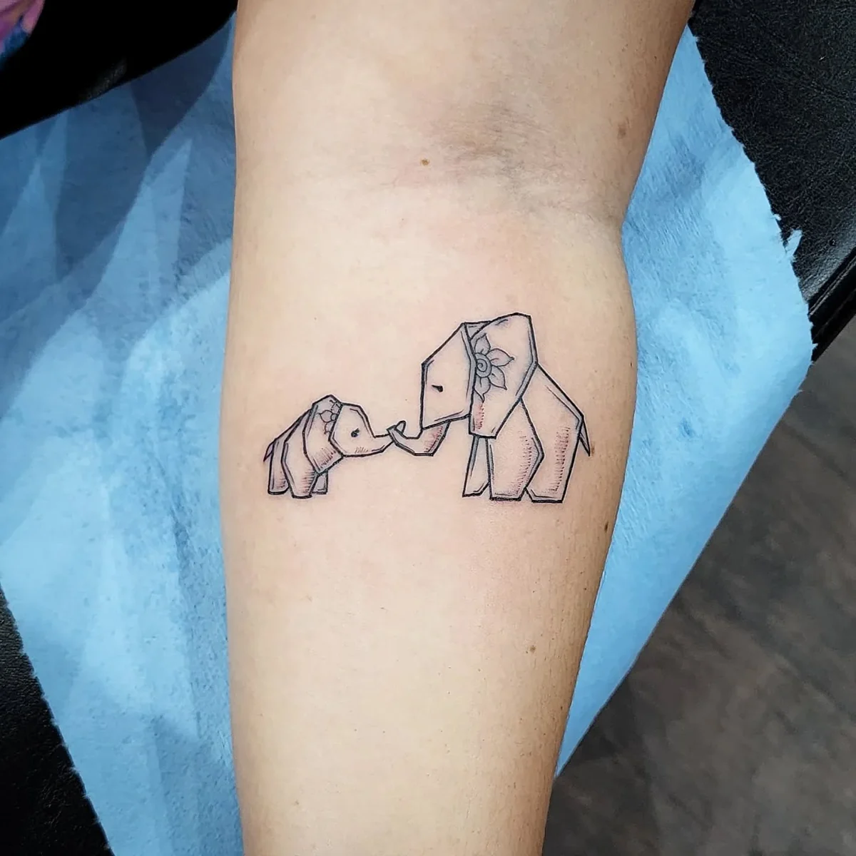 Elefantes de origami — tatuaje pequeño de Kozo en antebrazo